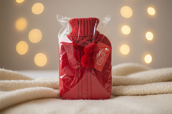 کیسه آب گرم امسیگ مدل HB202 Plus قرمز بافتنی روی پتو