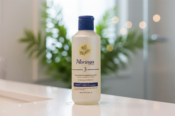 شامپو مغذی موهای آسیب دیده شماره ۳ مورینگا روی پیشخوان حمام