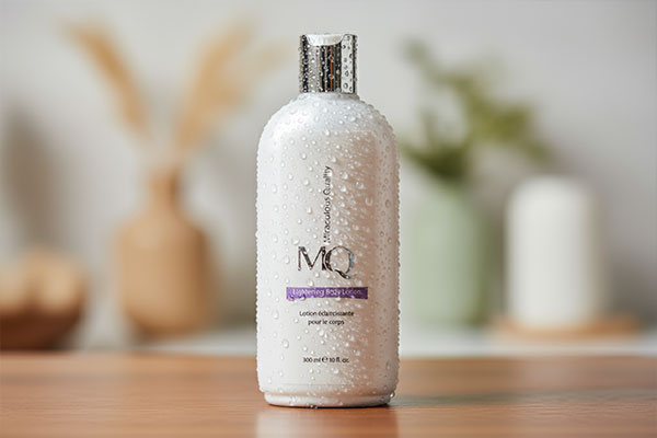 نمای نزدیک از لوسیون روشن کننده بدن MQ با قطرات آب