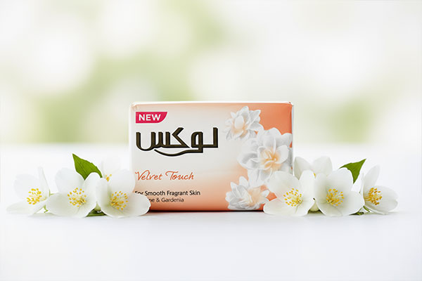 صابون معطر یاس و گاردنیا لوکس در کنار گل‌های یاس تازه