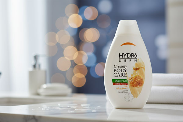 شامپو بدن کرمی شیر و عسل هیدرودرم روی پیشخوان حمام