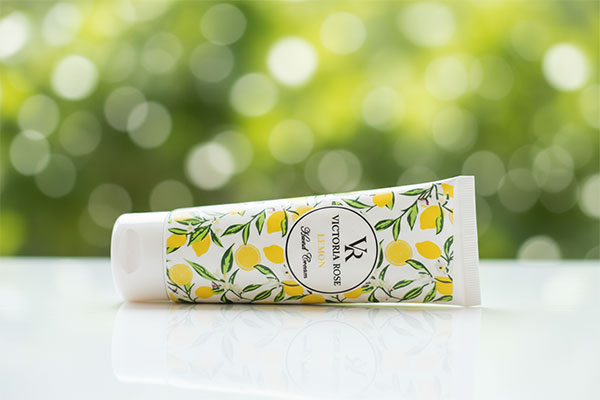 کرم دست لیمو ویکتوریا رز روی سطح سفید با پس زمینه سبز