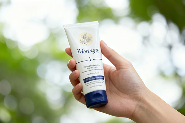 تصویر کرم دست فوق سبک مورینگا 1 در دست