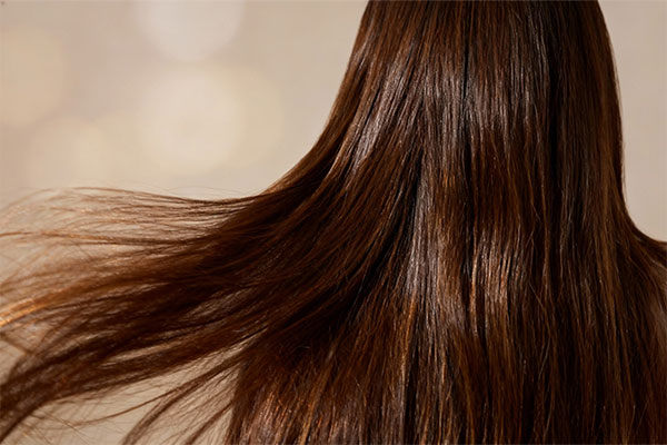 تصویر نزدیک از نرم کننده موهای رنگ شده بیول با قطرات آب