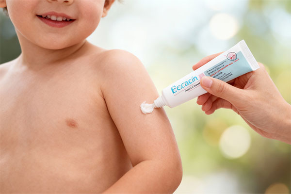 دست مهربان در حال استفاده از کرم اگزاسین کودک برای پوست حساس